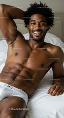 Relaxed young man smiling while lying on bed