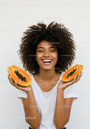 Joyful Woman Holding Fresh Papayas with Bright Smile