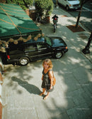 Woman Standing on City Sidewalk Surrounded by Urban Environment