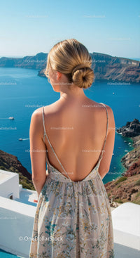 Woman in floral dress overlooking serene coastal cliffs