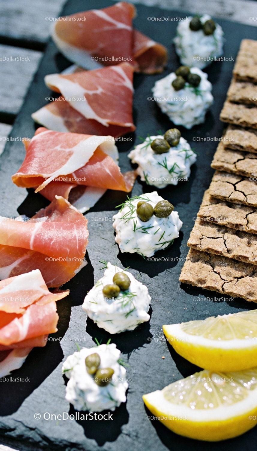 Appetizer platter with prosciutto, cream cheese, and crackers