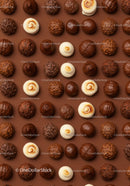 Assorted gourmet chocolate truffles on brown background