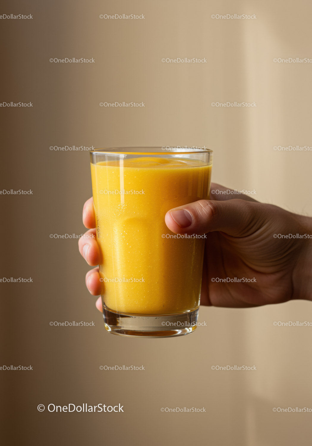 Hand Holding Glass of Fresh Mango Smoothie