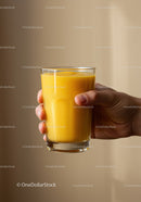 Hand Holding Glass of Fresh Mango Smoothie