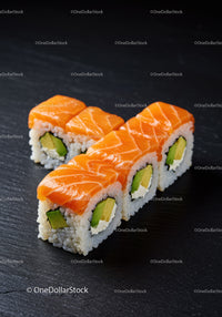 Fresh salmon avocado sushi rolls on black plate