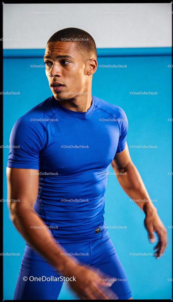 Focused male athlete training in vibrant blue sportswear