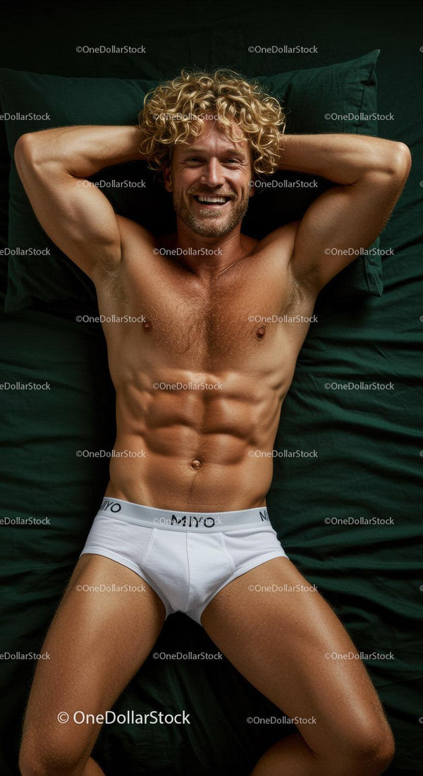 Smiling fit man relaxing on dark green bed in white briefs