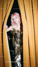 Woman with Pink Hair Peeking Through Velvet Curtains