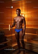 Young Fit Man in Blue Swimming Briefs Outdoors in Sauna Room