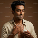 Young Man Applying Lotion for Skincare Routine in Studio