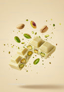 Close up of white chocolate with pistachio nuts falling