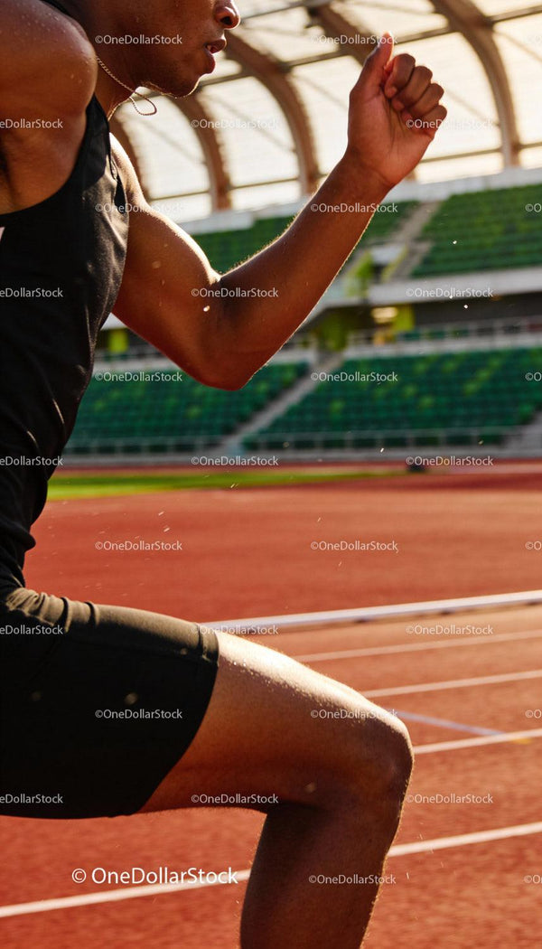 Close-up of male athlete sprinting on outdoor track