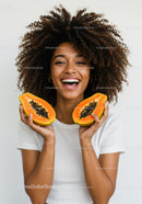 Joyful Woman Holding Halved Papaya with Bright Smile in Studio
