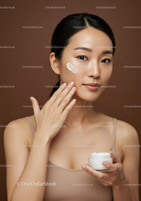 Young Woman with Clear Skin Applying Moisturizer in Skincare Routine