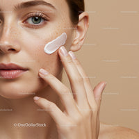 Close-up of Woman Applying Skincare Cream to Face with Freckles