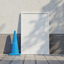 Blue Traffic Cone Next to Blank White Poster Frame