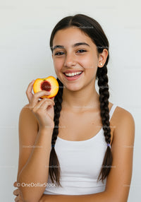 Young Girl Smiling While Holding Peach with Raspberry Center