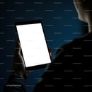 Person holding tablet with bright blank screen at night