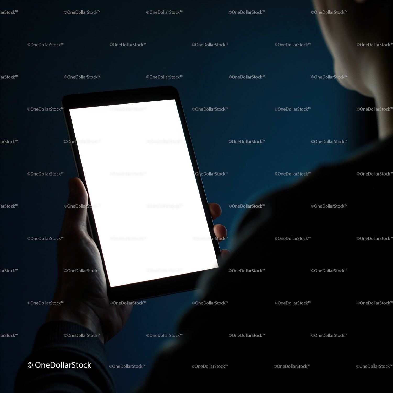 Osoba trzymająca tablet z jasnym, pustym ekranem w nocy