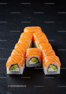 Fresh salmon avocado sushi rolls on black slate