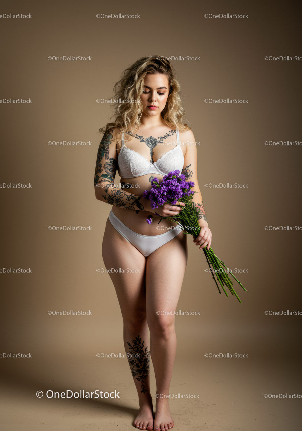 Tattooed Woman Holding Purple Flowers in Lingerie Studio Portrait