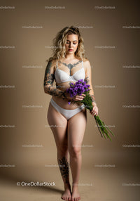 Tattooed Woman Holding Purple Flowers in Lingerie Studio Portrait