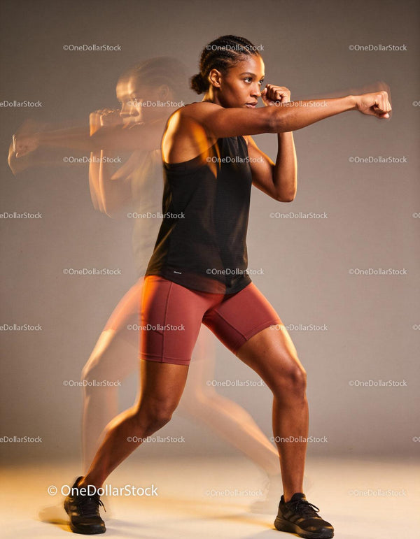 Athletic woman practicing boxing punches with intensity