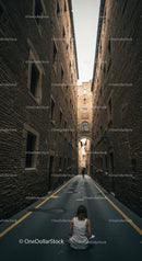 Woman in white dress sitting in narrow urban alleyway