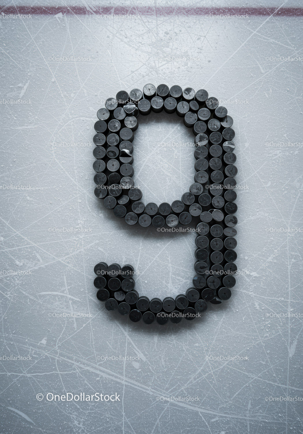 Number nine formed with hockey pucks on ice rink surface