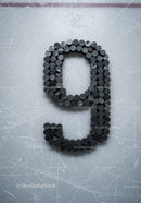 Number nine formed with hockey pucks on ice rink surface