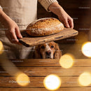 Woman Holding Fresh Bread While Dog Watches from Table