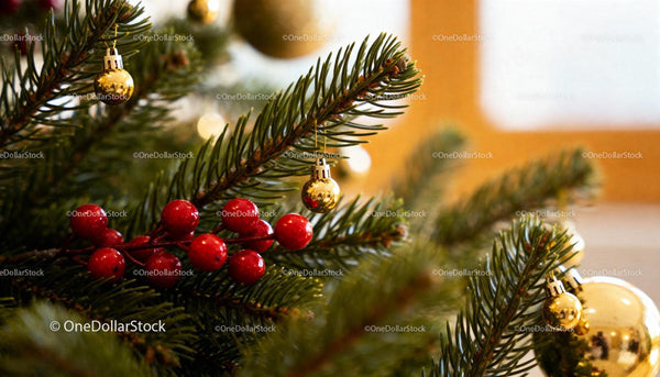Close-up of Christmas tree with golden baubles and berries