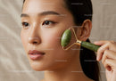 Asian Woman Using Jade Roller for Facial Skincare and Relaxation