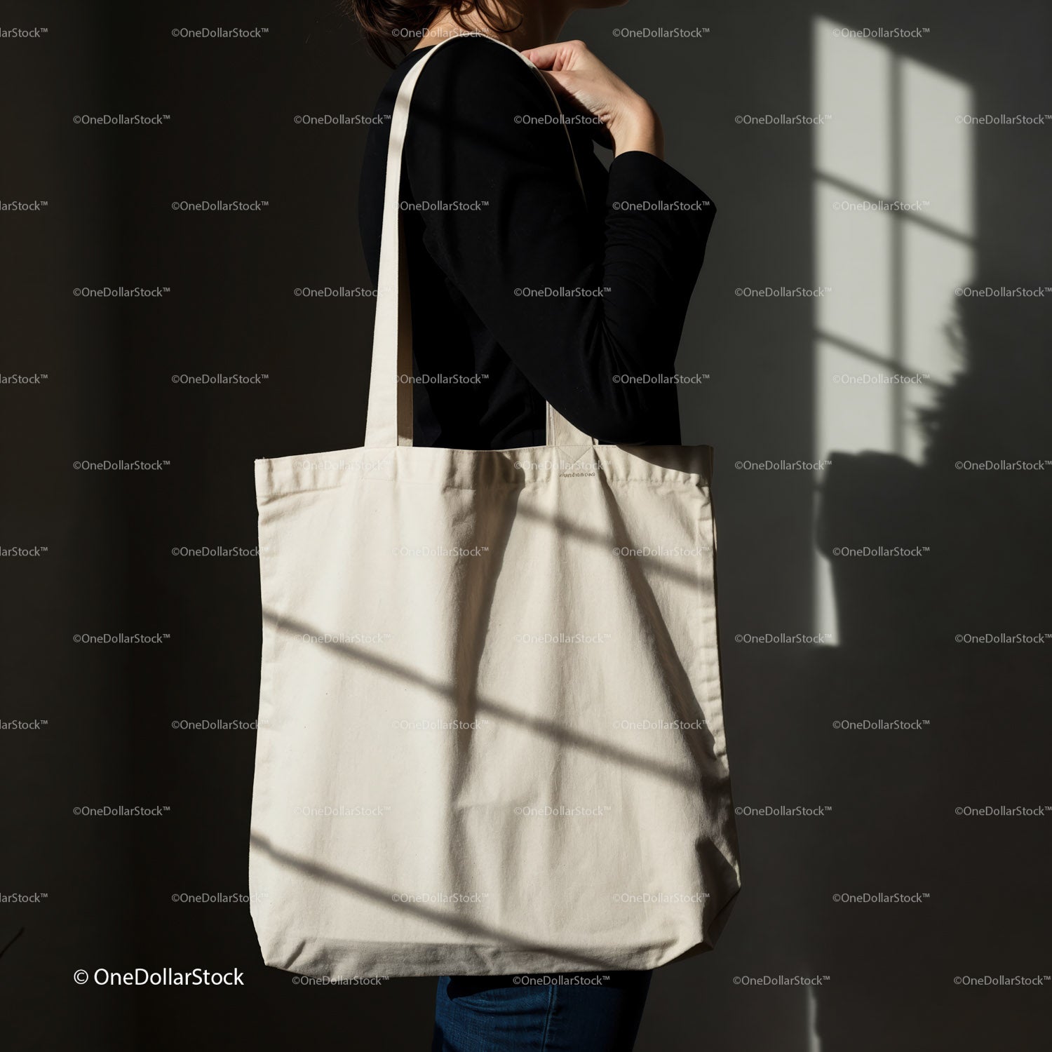 Minimalist canvas tote bag carried by woman in shadow