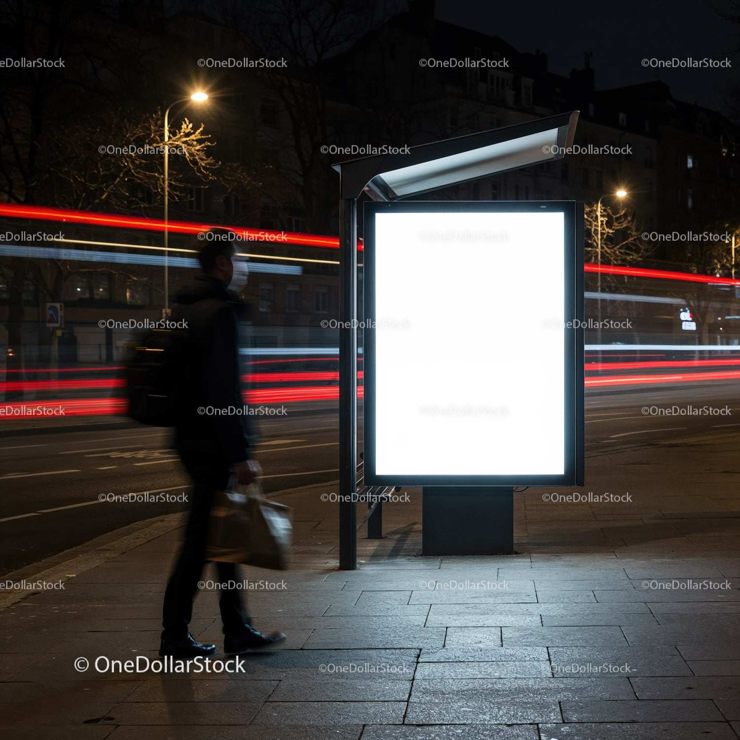 Man walking past illuminated blank billboard at night