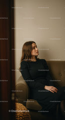 Elegant Woman Sitting on Sofa in Cozy Modern Interior with Calm Ambiance