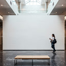 Woman walking in modern art gallery with blank wall