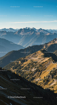 Majestic Mountain Range with Forested Hills Under Clear Blue Sky