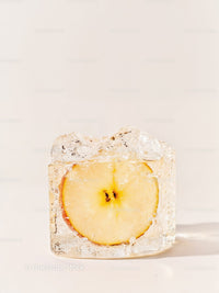 Frozen apple slice captured inside clear ice cube