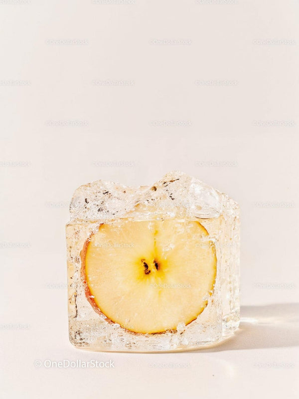 Frozen apple slice captured inside clear ice cube