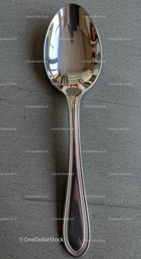 Classic stainless steel spoon on gray textured surface