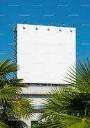 Blank Billboard Mounted Above Building with Palm Trees