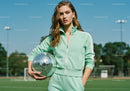 Young Woman in Mint Green Tracksuit Holding Disco Ball Outdoors