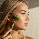 Beautiful woman receiving facial massage with jade roller for skin rejuvenation