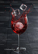 Red Beverage Splash with Ice Cubes in Wine Glass
