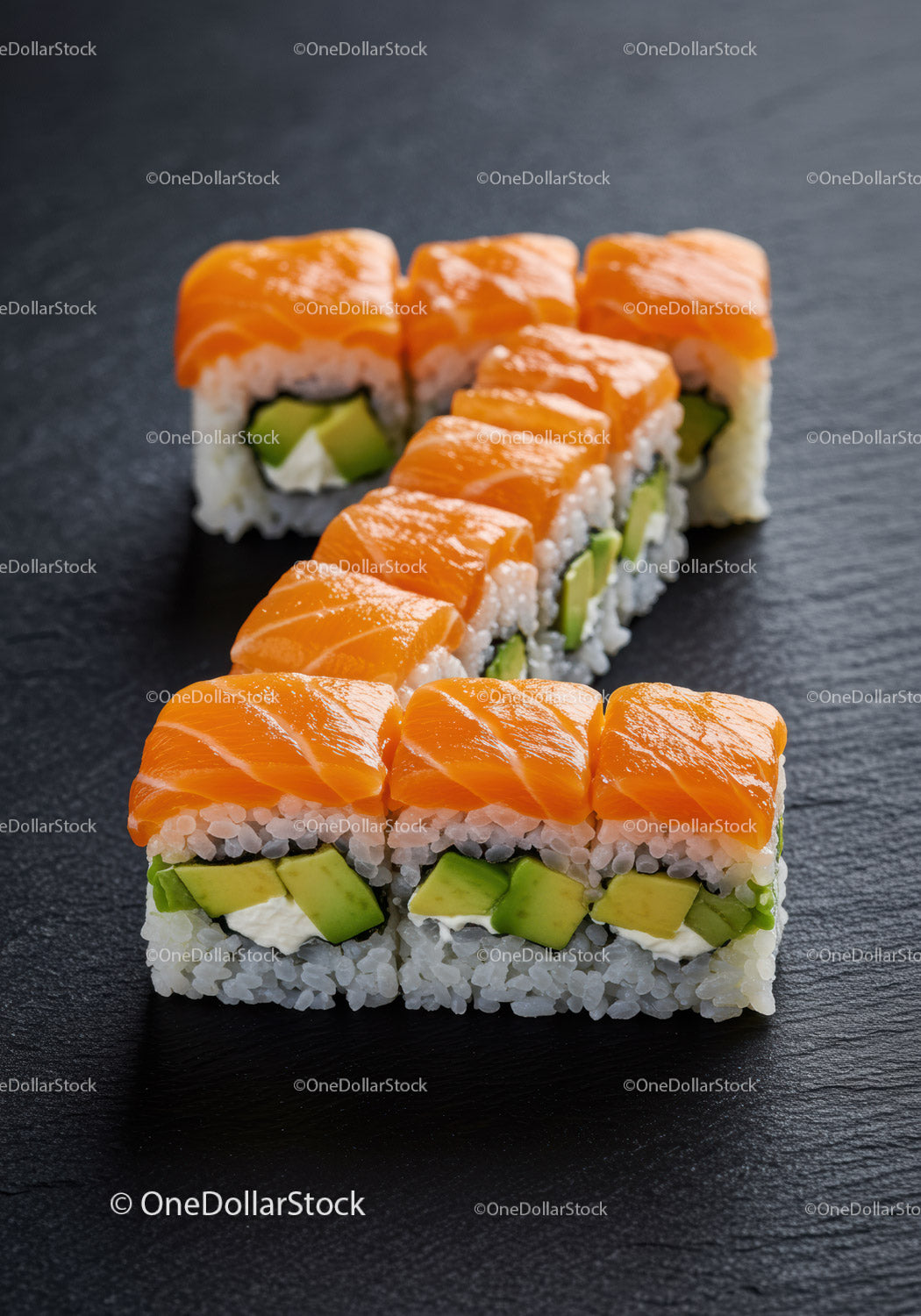 Świeże rolki sushi z łososiem i awokado na czarnym łupku