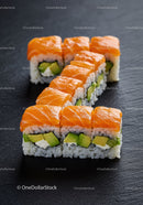 Fresh salmon avocado sushi rolls on black slate