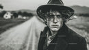 Black and White Portrait of Young Man with Curly Hair and Fedora Hat