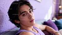 Thoughtful young man resting on purple couch indoors
