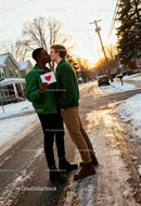 Couple Sharing a Kiss Holding Heart Card Outdoors